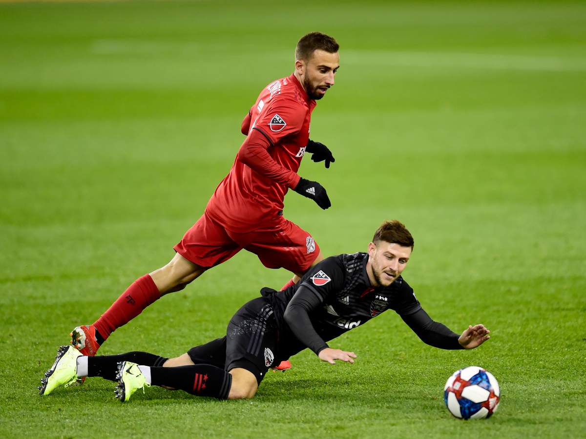 D.C. United forward Paul Arriola (7) goes down as Toronto FC midfielder Nicolas Benezet (7) chases the ball during first half MLS playoff soccer action in Toronto on Saturday, Oct. 19, 2019.