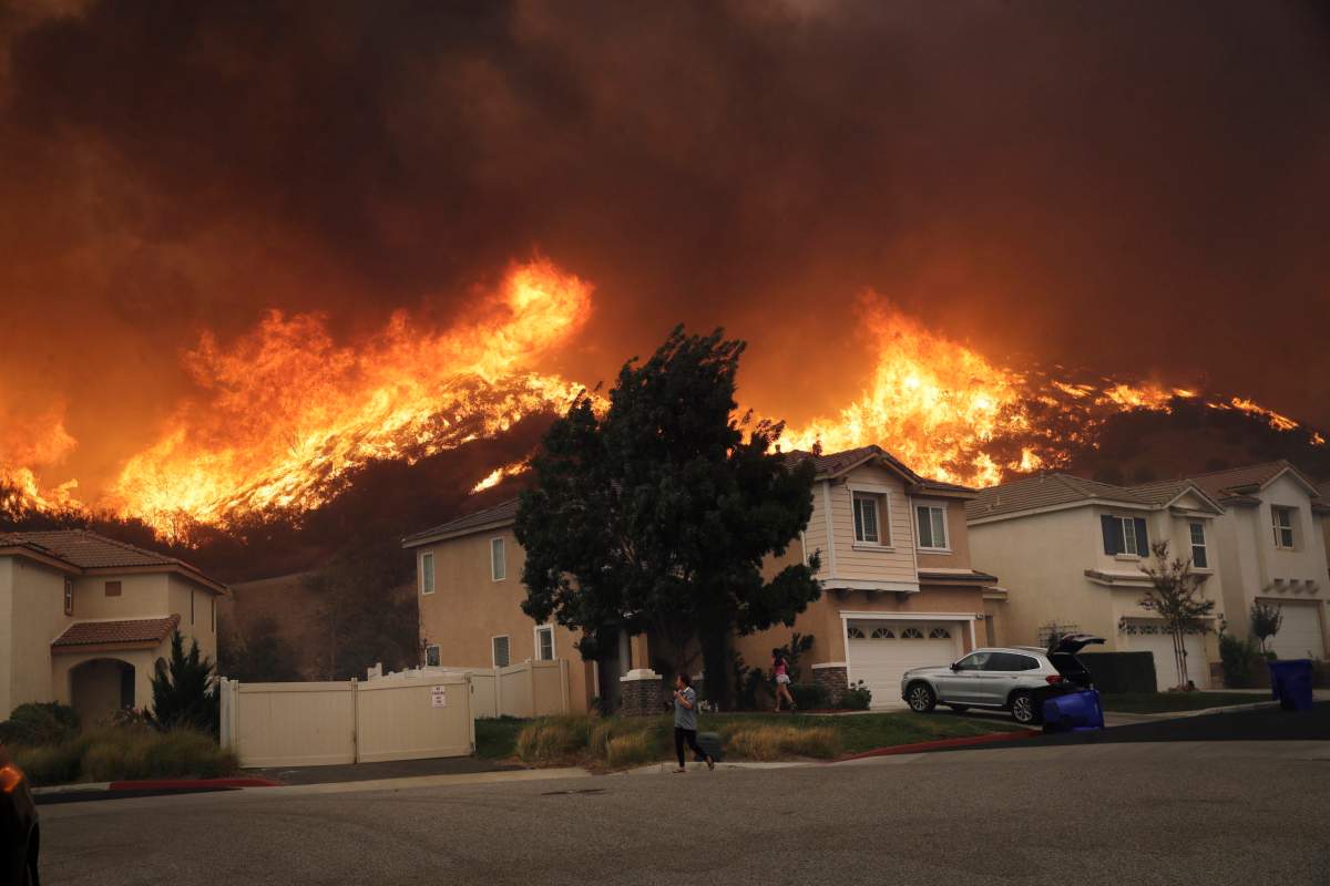 A wildfire approaches a residential subdivision Thursday, Oct. 24, 2019, in Santa Clarita, Calif.
