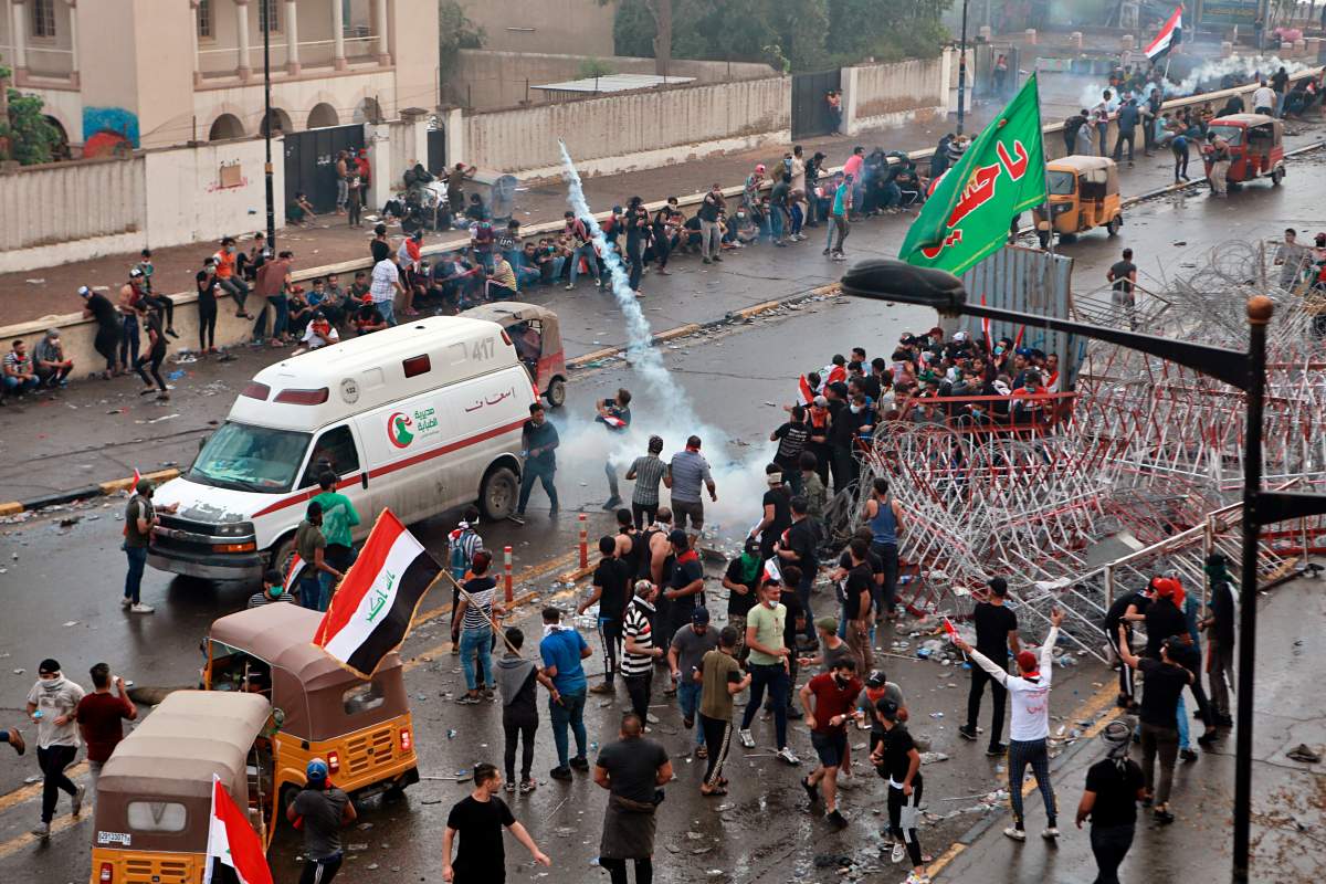 Iraqi security forces fire tear gas to disperse anti-government protesters during a demonstration in central Baghdad, Iraq, Friday, Oct. 25, 2019.