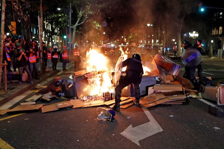 Catalan regional Riot police members try to put out the fire of a barricade during a protest in Barcelona, Spain, 26 October 2019.