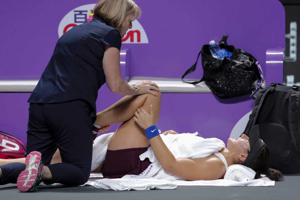 Bianca Andreescu of Canada receives a medical treatment on her leg after suffering a knee injury during the WTA Finals Tennis Tournament against Karolina Pliskova of the Czech Republic in Shenzhen, China's Guangdong province, Wednesday, Oct. 30, 2019. 