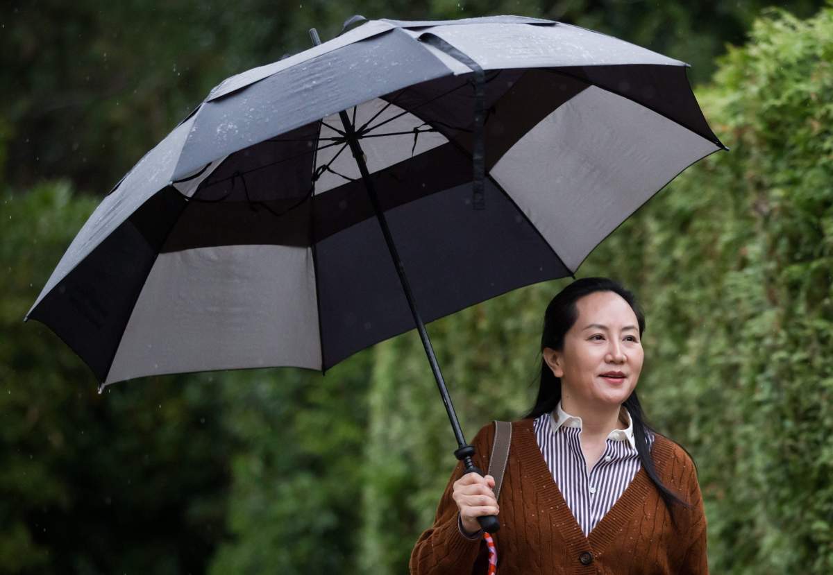 Huawei chief financial officer Meng Wanzhou, who is out on bail and remains under partial house arrest after she was detained last year at the behest of American authorities, carries an umbrella to shield herself from rain as she leaves her home to attend a court hearing, in Vancouver, on Thursday October 3, 2019.