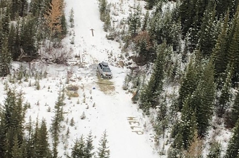 The word "help" and an arrow are seen scrawled into the snow from a RCMP aircraft that was searching for a missing couple in the southeast  B.C. backcountry on Oct. 31, 2019.