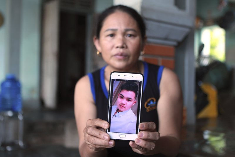 Hoang Thi Ai holds up her phone showing a photo of her son Hoang Van Tiep, who she fears is one of the possible victims in the truck deaths in England, at her home in Dien Chau district, Nghe An province, Vietnam on Monday, Oct. 28, 2019. 