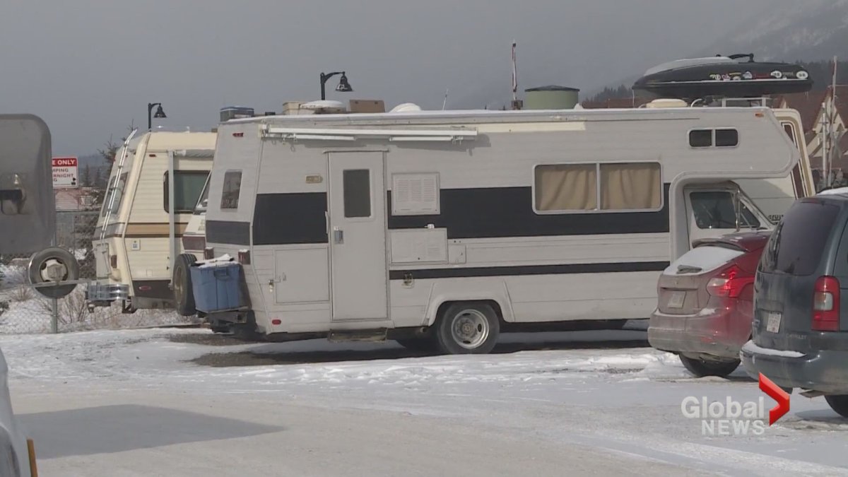 Vans and campers where people live are seen in a parking lot in Canmore. 