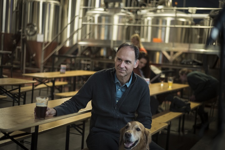 Steve Himel of Henderson Brewing, poses for a photograph with Louis the dog, in Toronto.