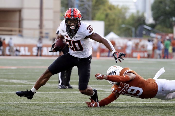 Oklahoma State running back Chuba Hubbard (30) runs past Texas defensive back Brandon Jones (19) during the first half of an NCAA college football game Saturday, Sept. 21, 2019, in Austin, Texas.