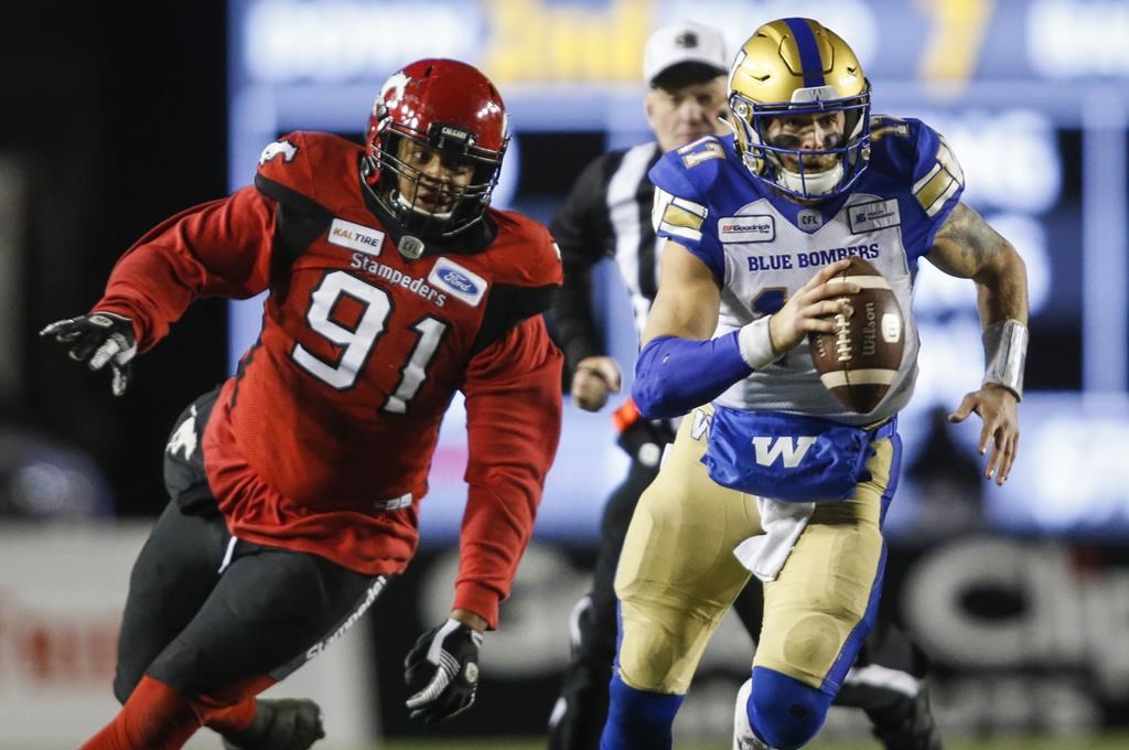 Winnipeg Blue Bombers quarterback Chris Streveler, right, gets away from Calgary Stampeders' Mike Rose during second half CFL football action in Calgary, Saturday, Oct. 19, 2019. Blue Bombers starting quarterback Chris Streveler was absent from Tuesday's practice. THE CANADIAN PRESS/Jeff McIntosh.