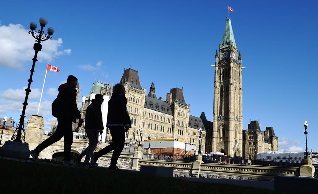 People walk near Parliament Hill in Ottawa on Wednesday, Oct. 23, 2019.