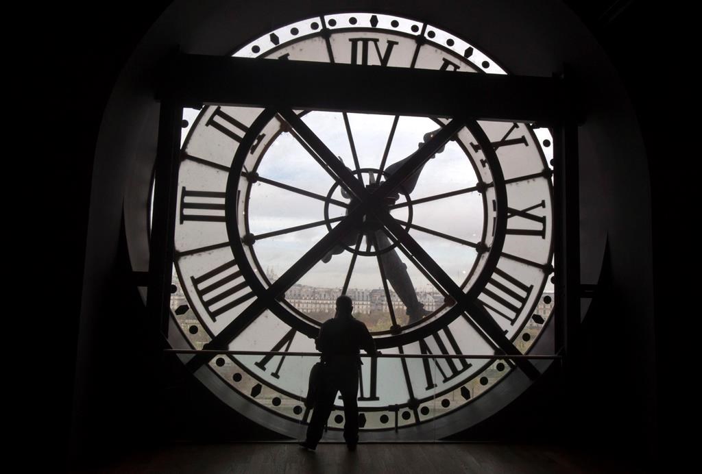 A visitor looks through the clock of the Orsay museum, overlooking Paris, Thursday, Oct. 16, 2014. THE CANADIAN PRESS/AP, Michel Euler