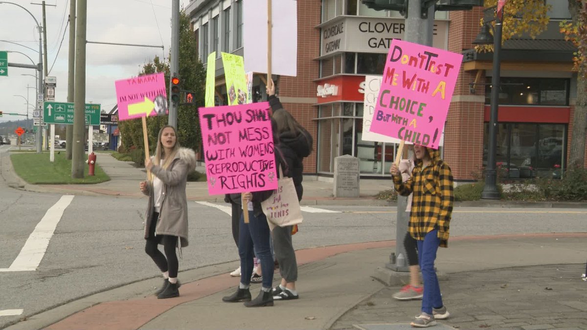 Protesters stand outside Tamara Jansen's Cloverdale campaign office on Monday, Oct. 14, 2019. 