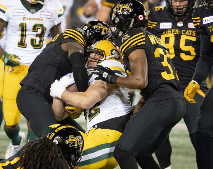 Edmonton Eskimos running back Christion Jones (22) is tackled by a swarm of Hamilton Tiger Cats during first half CFL football game action in Hamilton, Ont., Friday, Oct. 4, 2019. 