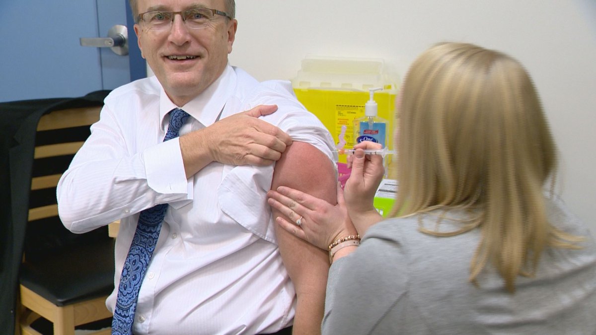 Saskatchewan health minister Jim Reiter rolls up his sleeve Tuesday morning as flu shots become available across the province. 