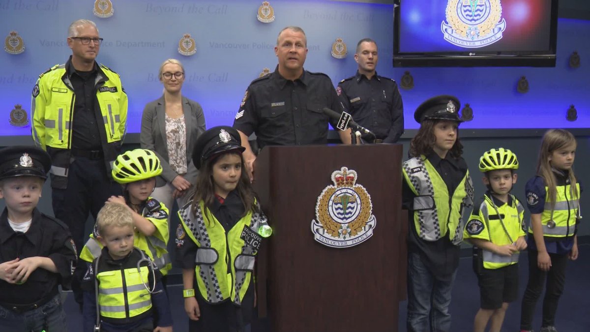 Vancouver police Sgt. Aaron Roed poses with kids to highlight safety and visibility on Halloween night. 