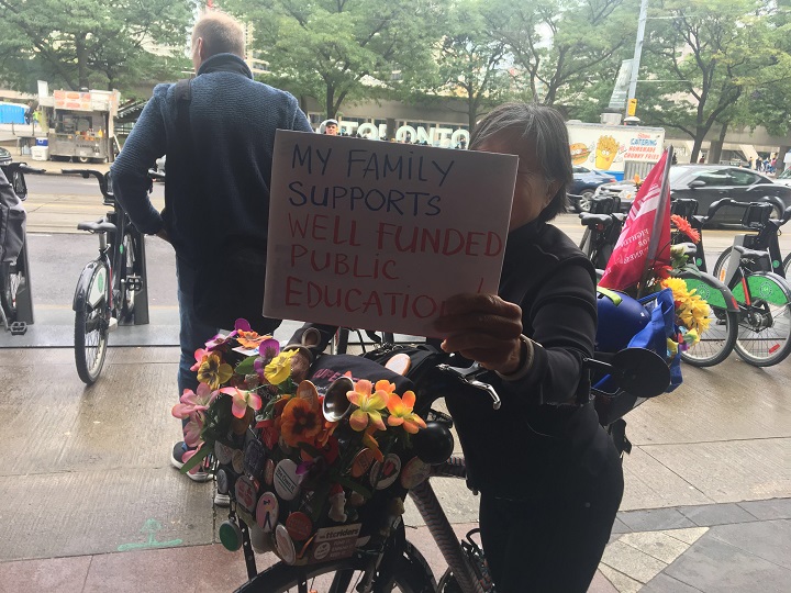 Parents rally together outside the Sheraton hotel in downtown Toronto in support of CUPE workers and asking for the government to reach a settlement.