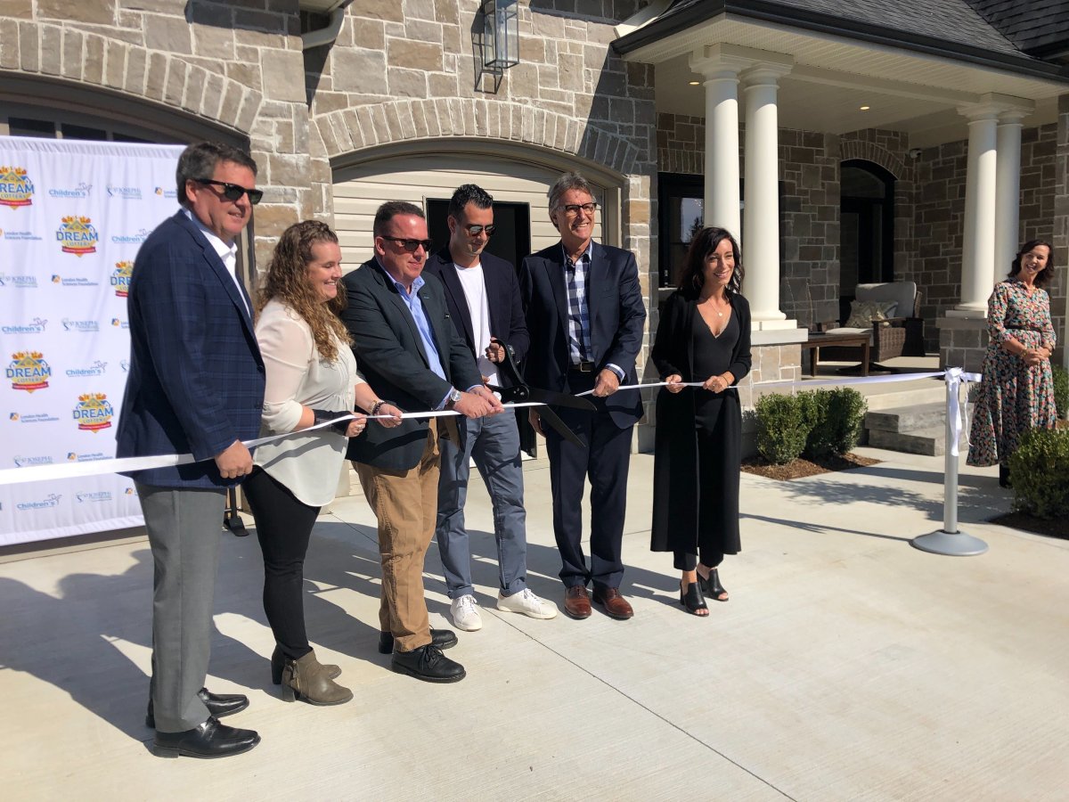 Officials cut the ribbon at the Highland Green Estates Dream Home at 54 Edwin Drive in London on Oct. 10, 2019.