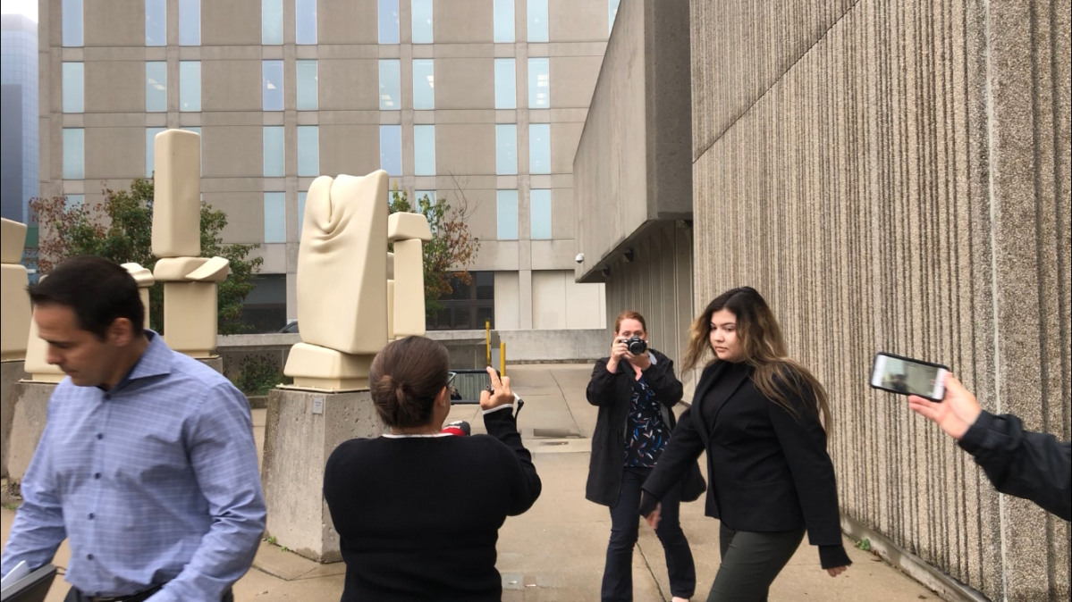 Daniella Leis, 24, is photographed by media as she leaves a London, Ont., courthouse on Oct. 2, 2019.