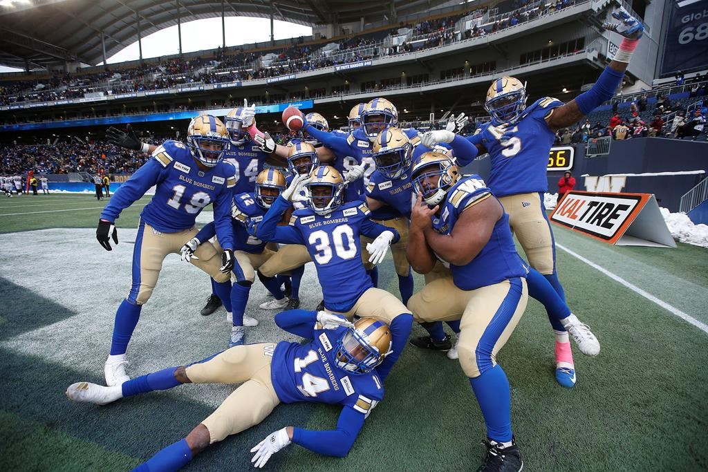 Winnipeg Blue Bombers' Nick Taylor (25), holding ball, and teammates celebrate his interception and touchdown during the second half of CFL action against the Montreal Alouettes, in Winnipeg, Saturday, Oct. 12, 2019.