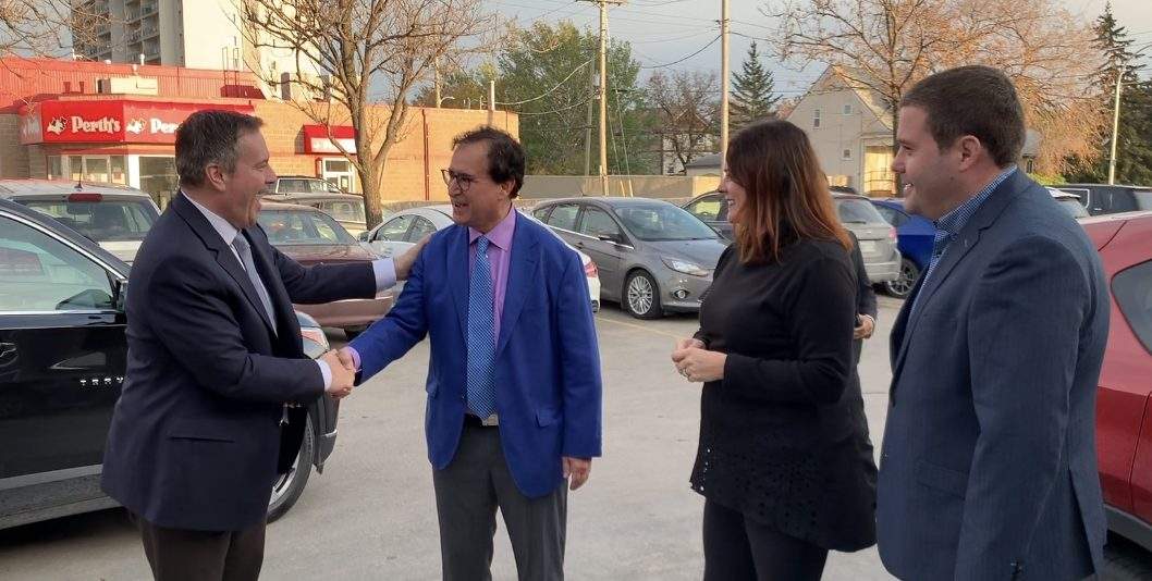 Alberta premier Jason Kenney shakes hands with Conservative candidate Marty Morantz at his Winnipeg campaign office.