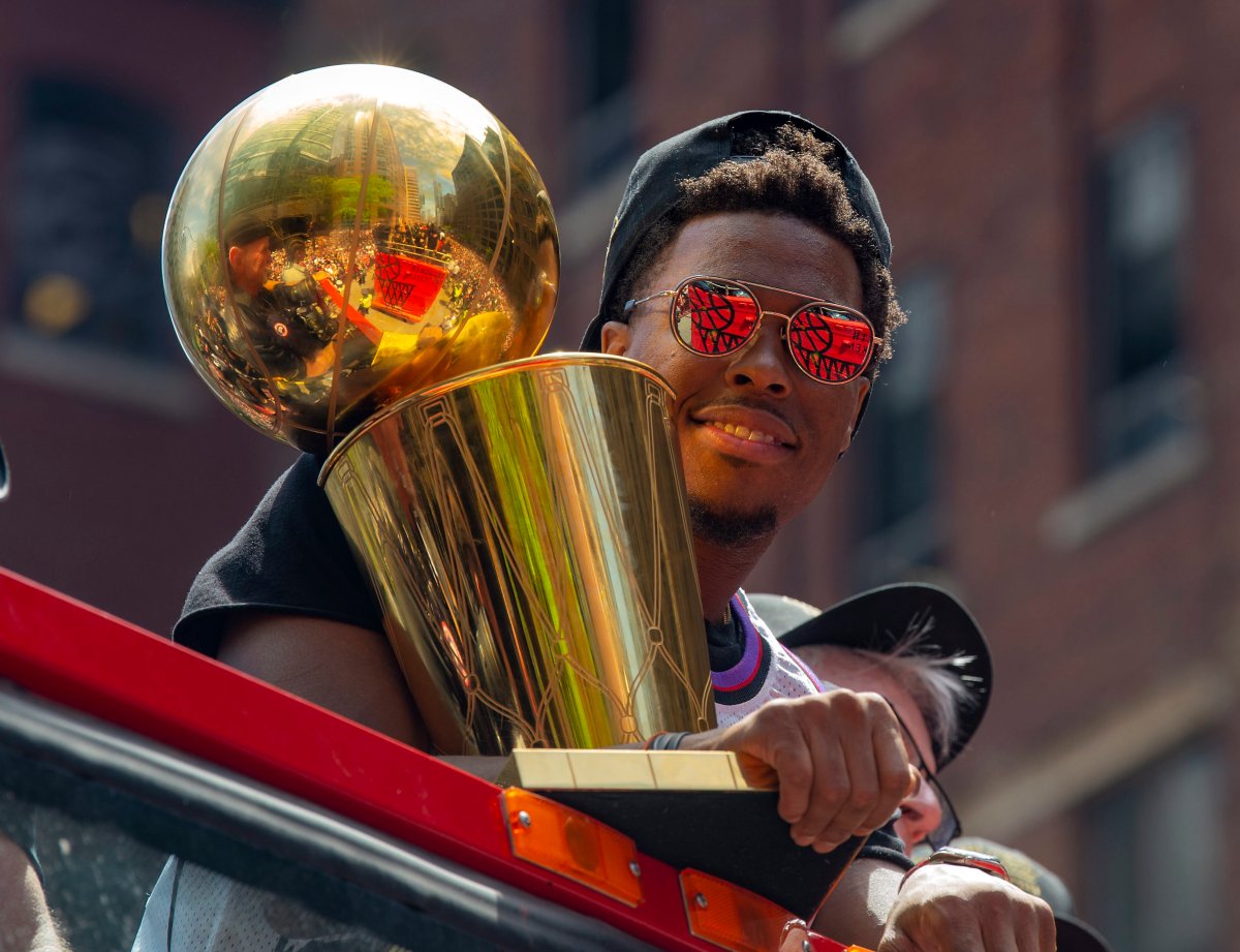 Toronto Raptors guard Kyle Lowry holds the Larry O'Brien trophy aboard an open bus during a victory parade through downtown Toronto, Canada, 17 June 2019.