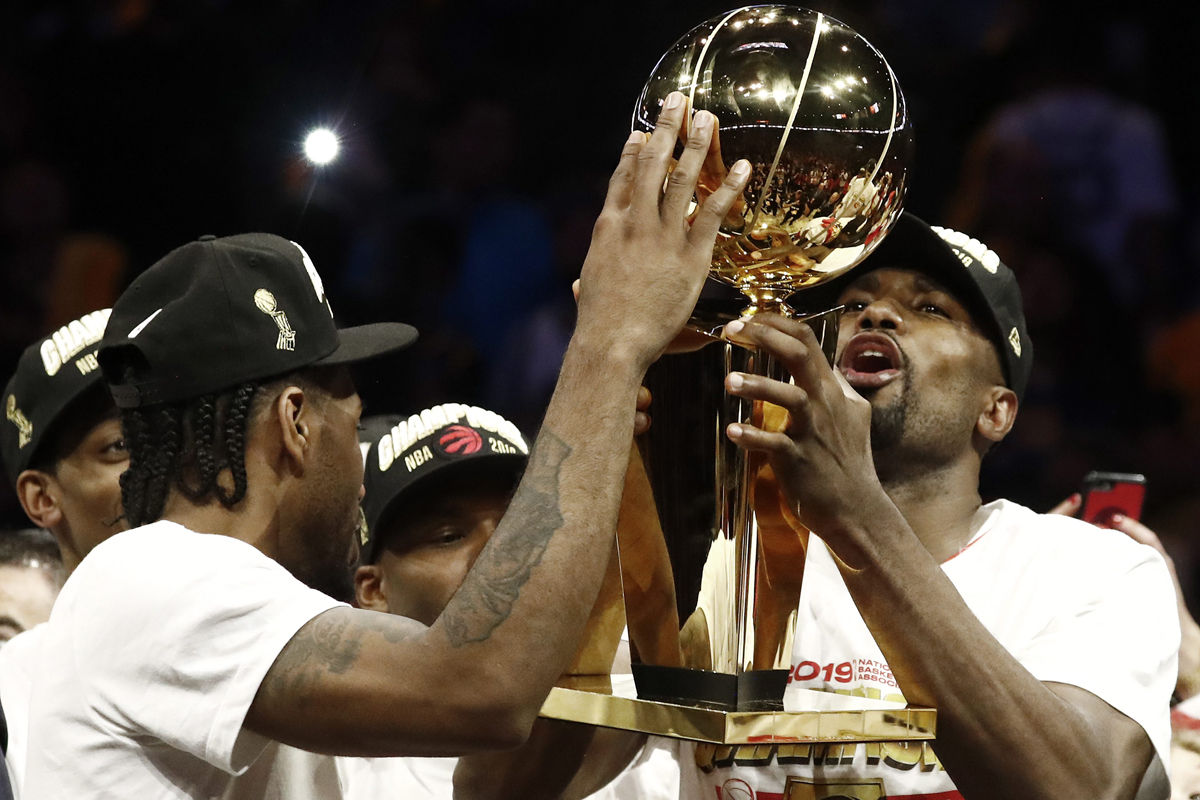 Toronto Raptors forward Serge Ibaka holds up the Larry O'Brien NBA Championship Trophy while teammate Kawhi Leonard touches it after beating the Golden State Warriors in the NBA at Oracle Arena, in Oakland on June 13.