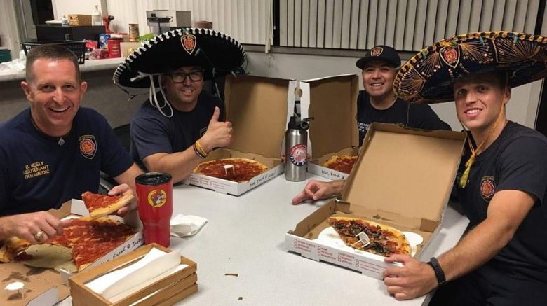 Pizza being served to firefighters in San Antonio, Tex., after they were accidentally ordered by an Alberta firefighter after a phone number mix-up.