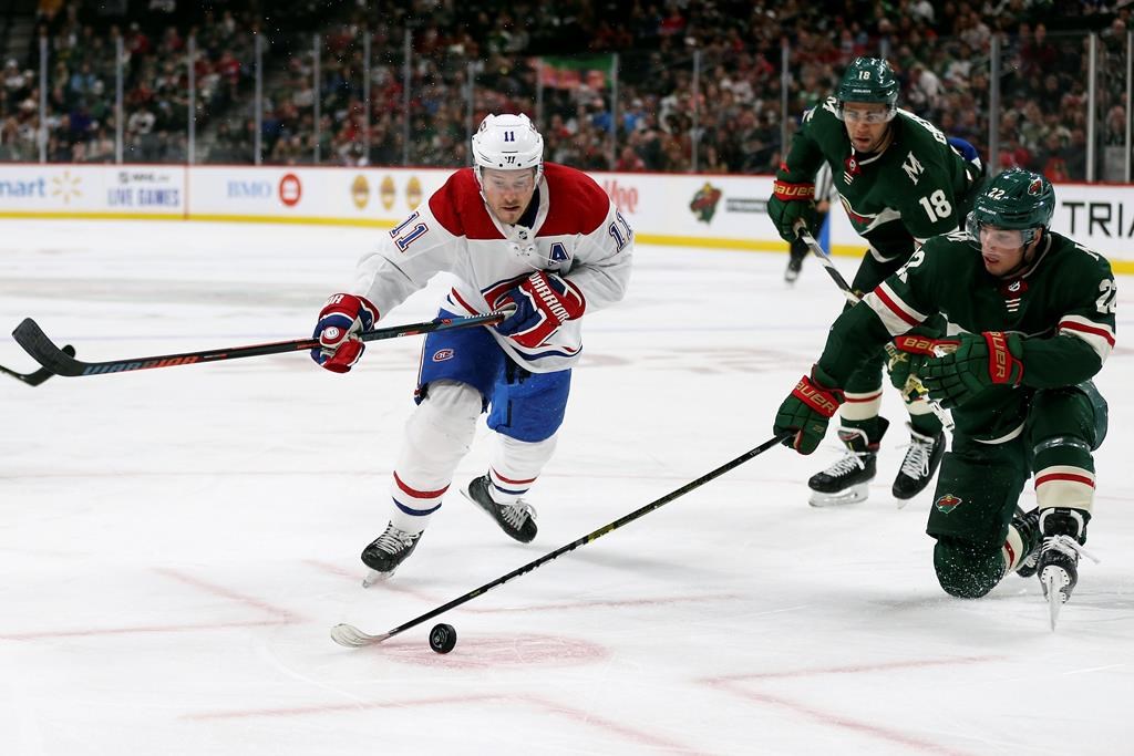 Minnesota Wild's Kevin Fiala (22) tries to gain control of the puck against Montreal Canadiens' Brendan Gallagher (11) in the second period of an NHL hockey game Sunday Oct. 20, 2019, in St. Paul, Minn.