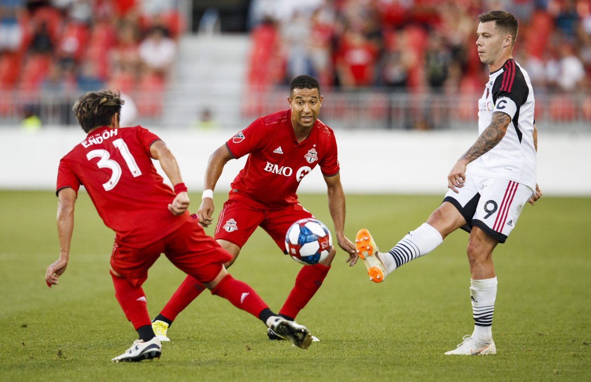 Ottawa Fury's Carl Haworth kicks the ball while being defended by Toronto FC's Justin Morrow, centre, and Tsubasa Endoh, left, during the first half of Canadian Championship soccer action in Toronto, Wednesday August 14, 2019.