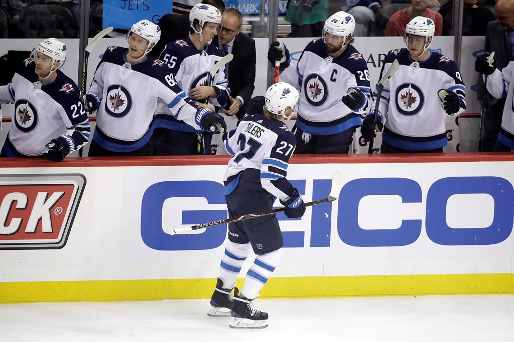 The Winnipeg Jets' Nikolaj Ehlers (27) returns to the bench after scoring during the first period of an NHL hockey game against the Pittsburgh Penguins in Pittsburgh, Tuesday, Oct. 8, 2019.