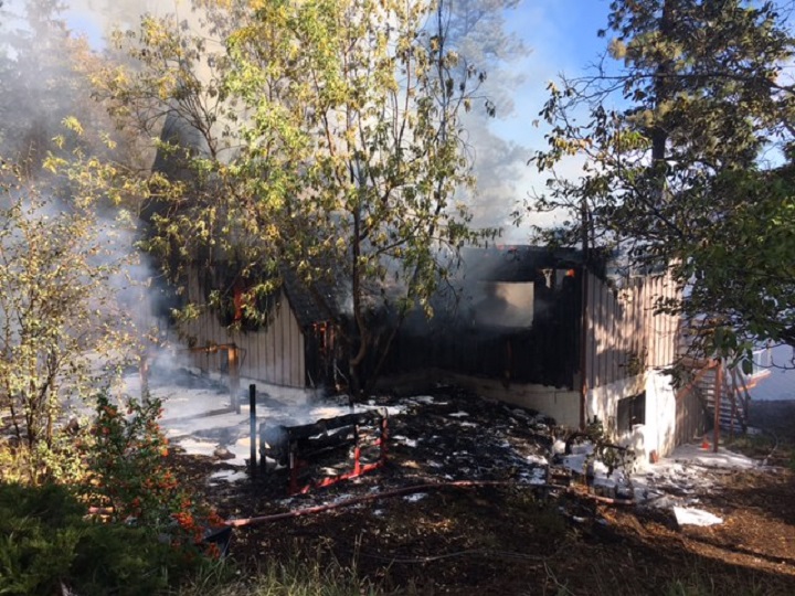 Smoke and steam rise from a house fire in Peachland on Tuesday morning.