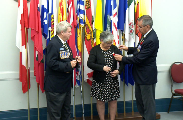 The lieutenant-governor of Saskatchewan receives the first poppy of the 2019 campaign at the government house in Regina on Friday.