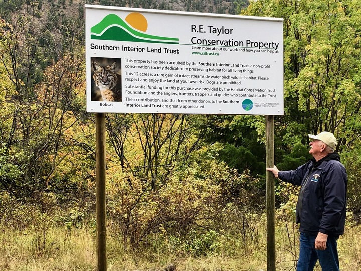 Ron Taylor, a longtime wildlife conservationist from Winfield, looks at a sign dedicating a section of land in his name following an unveiling late last month.