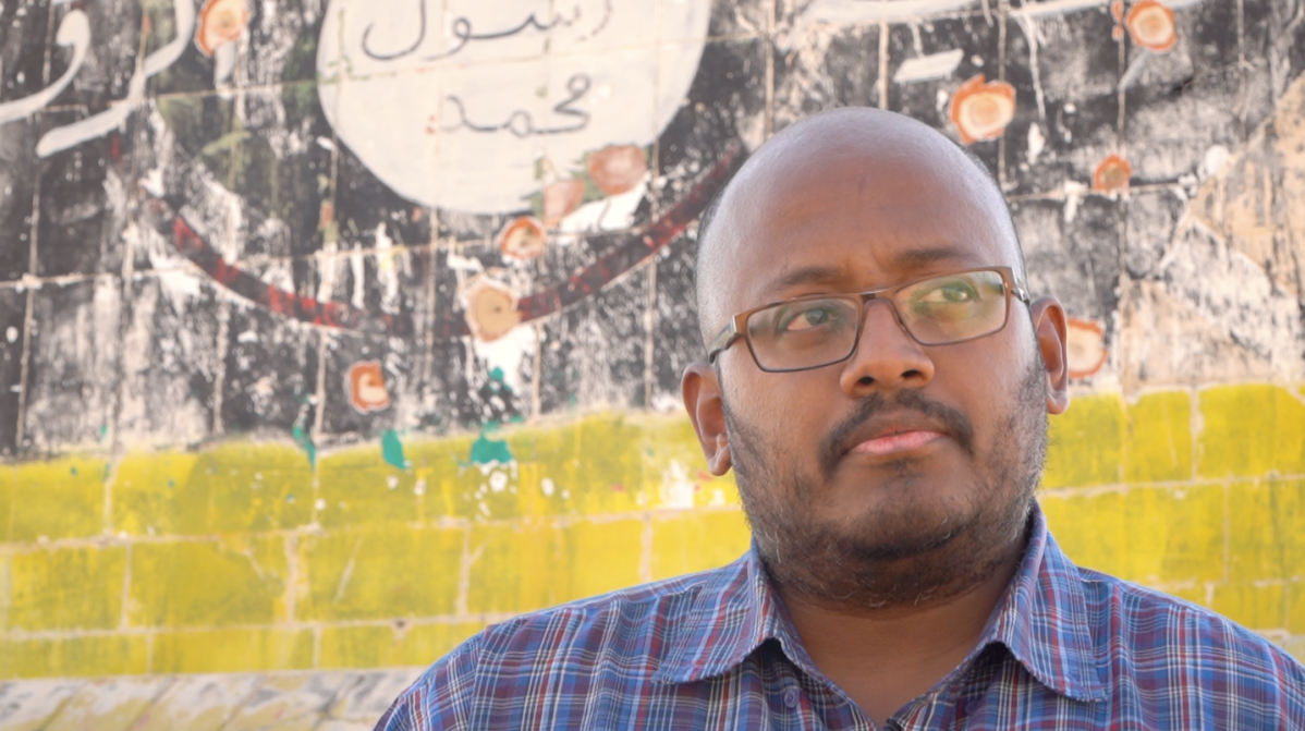 Foreign fighter expert Prof. Amarnath Amarasingam stands in front of an ISIS sign in northern Syria.