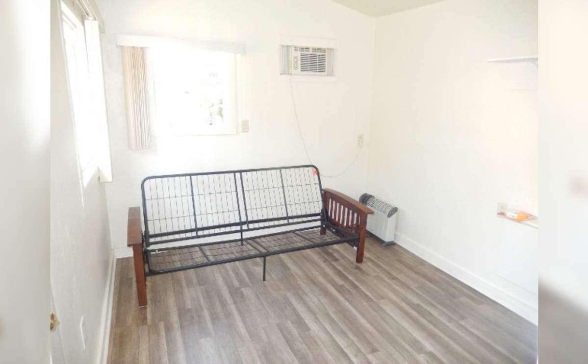 The space has room for a futon and also has a wall air conditioner.