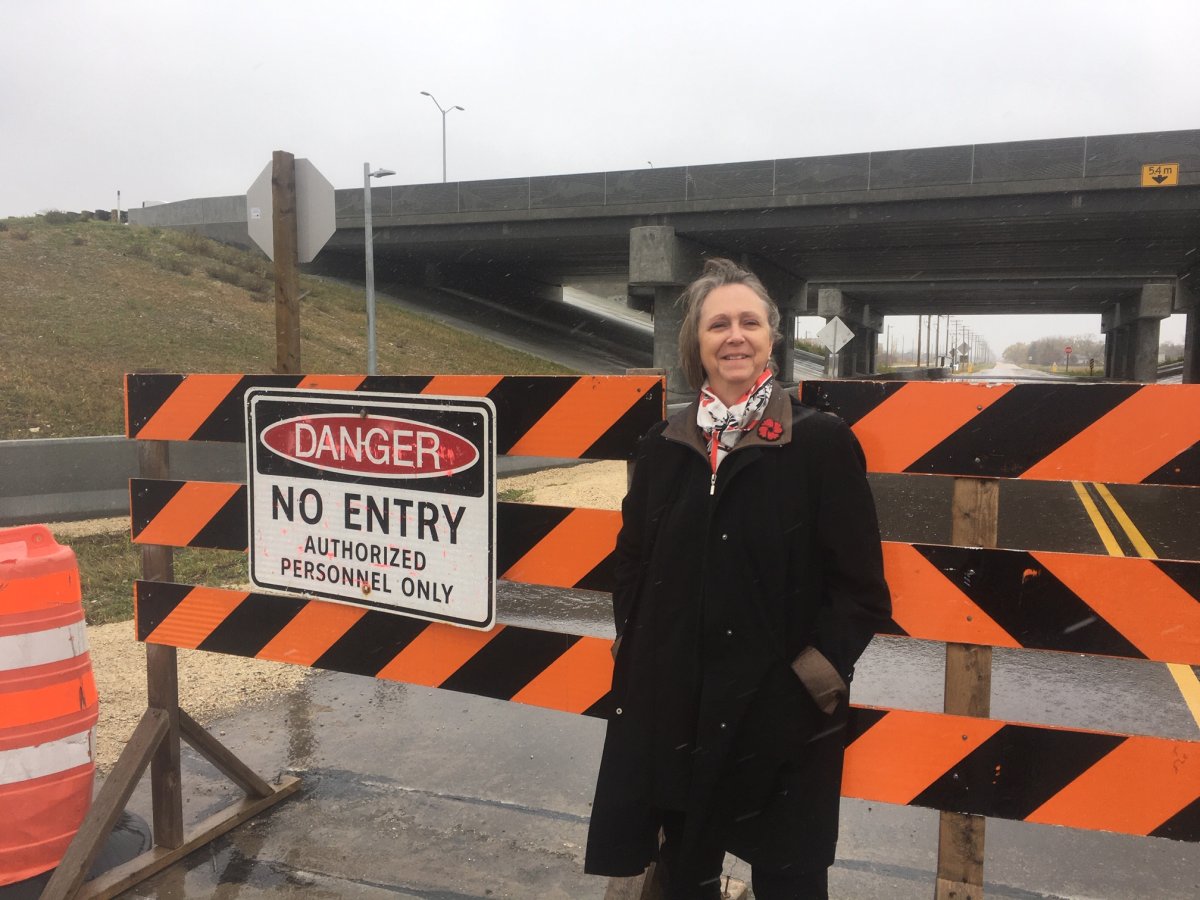 East St. Paul Mayor Shelley Hart in front of a road that remains barricaded despite being finished.