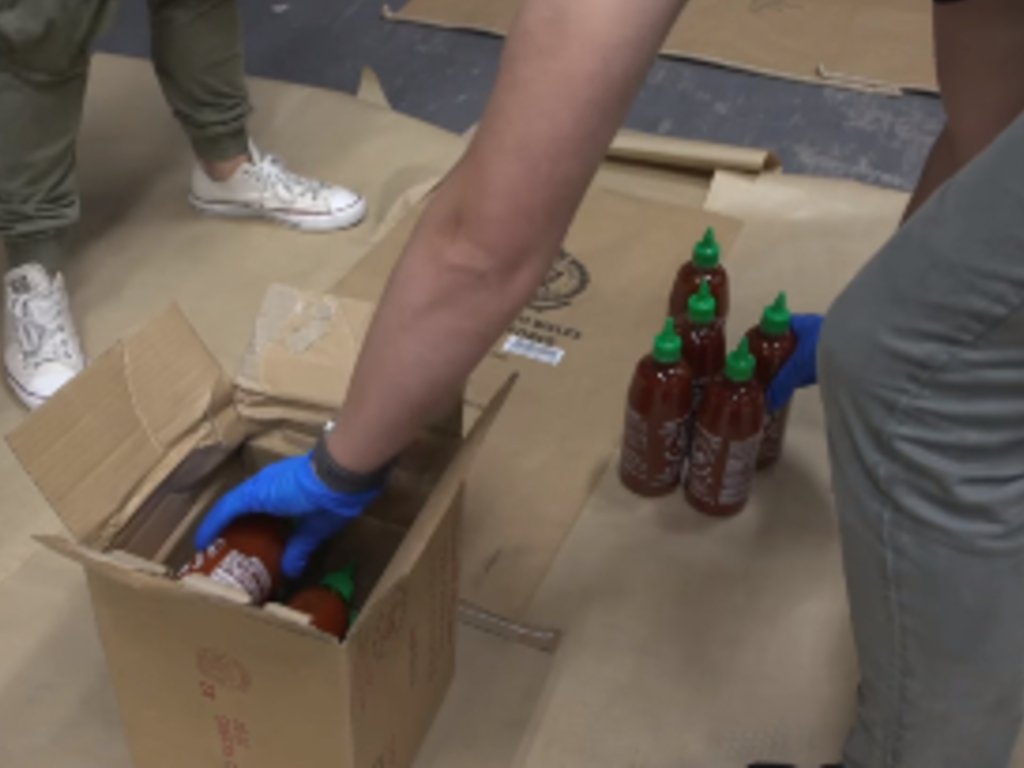 Four men have been charged with importing around 400 kilograms of methylamphetamine, stashed in sriracha bottles.