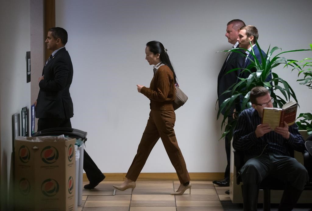 Huawei chief financial officer Meng Wanzhou, centre, who is out on bail and remains under partial house arrest after she was detained last year at the behest of American authorities, arrives at B.C. Supreme Court to attend a hearing, in Vancouver, on Thursday October 3, 2019.