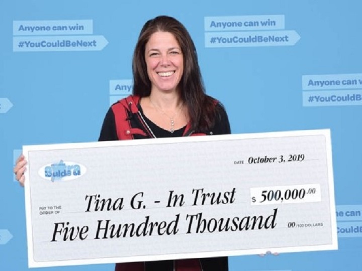 Tina Gauvin smiles while holding a presentation cheque from the B.C. Lottery Corporation for $500,000.