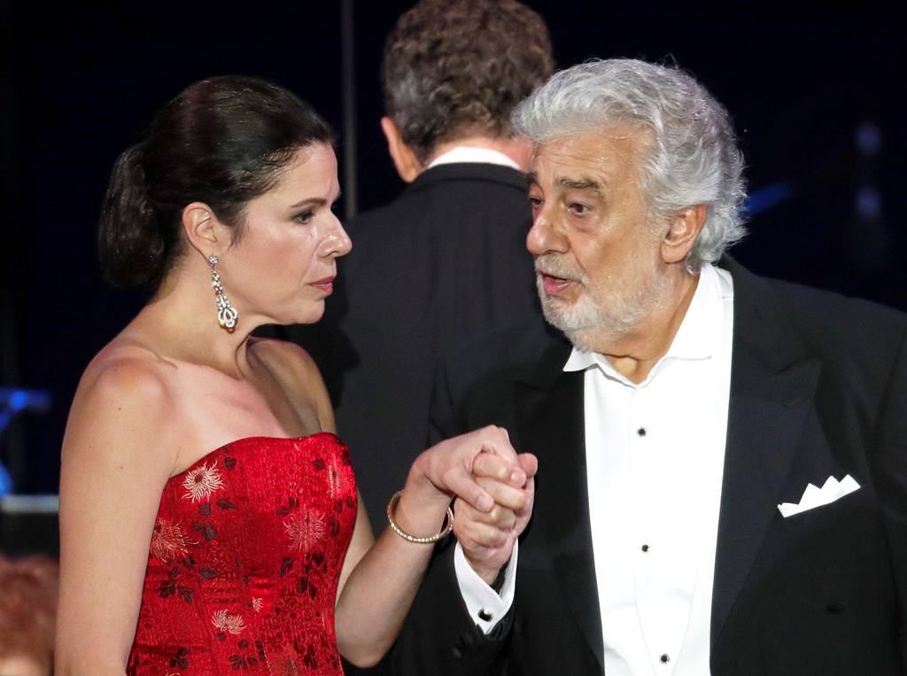 In this file photo taken on Aug. 28, 2019, Opera star Placido Domingo holds the hand of Ana Maria Martinez at the end of a concert in Szeged, Hungary.