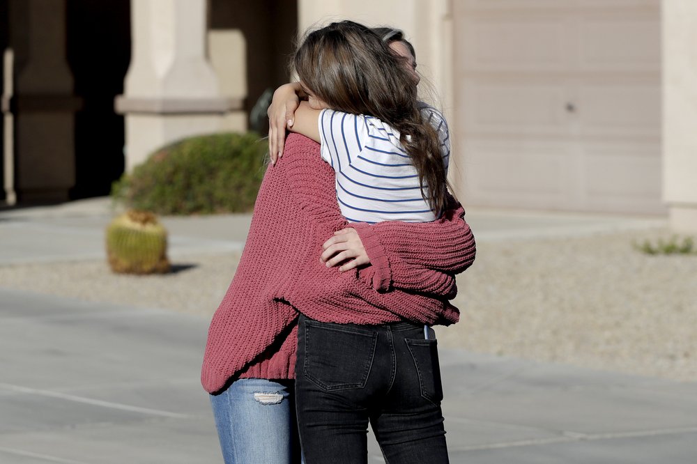 Madelyn Staddon, right, a relative of some of the members of a Mormon community who were attacked while traveling near the US-Mexico border, embraces a neighbor outside her home, Tuesday, Nov. 5, 2019, in Queen Creek, Ariz.