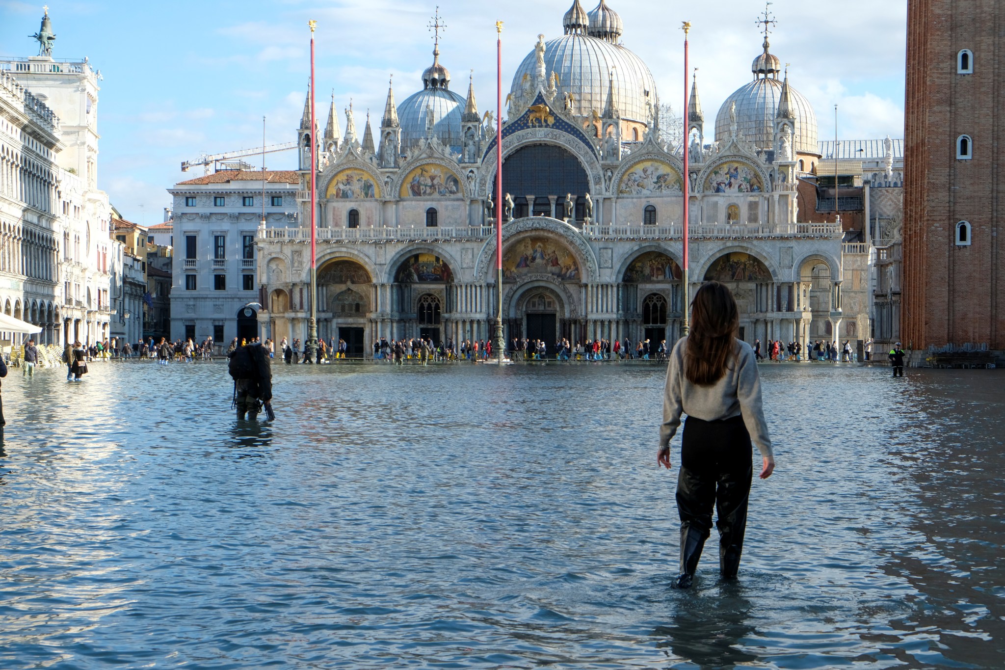 People walk in the flooded St. Mark’s Square during a period of seasonal high water in Venice, Italy, on Nov. 14, 2019.