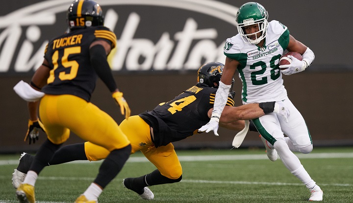 Loucheiz Purifoy tries to avoid a tackle from Curtis Newton during the first quarter between the Saskatchewan Roughriders and the Hamilton Ticats in CFL action on June 13, 2019 .