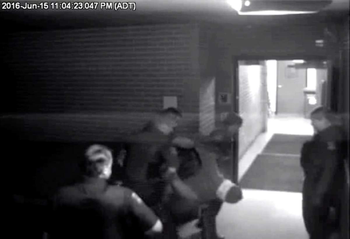 Police officers carry Corey Rogers into the Halifax police station, wearing a spit hood at about 11 p.m. on June 15, 2016 in this still image taken from surveillance video provided by Nova Scotia Courts. THE CANADIAN PRESS/HO, Province of Nova Scotia Courts