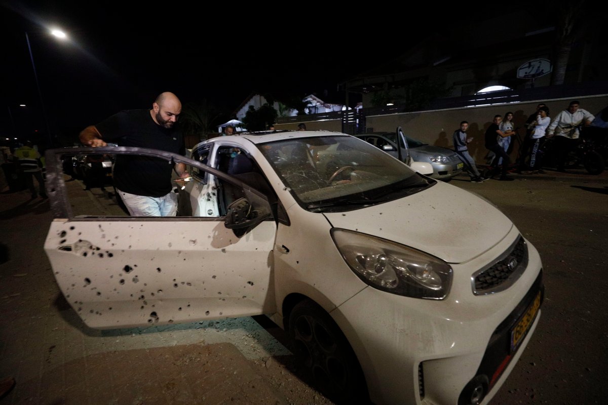 A man checks a car damaged by shrapnel from a missile fired from Gaza Strip in Sderot, Israel, Friday, Nov. 1, 2019. 