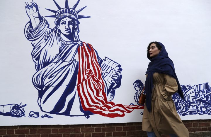 A woman walks past a satirical drawing of the Statue of Liberty after new anti-U.S. murals on the walls of former U.S. embassy unveiled in a ceremony in Tehran, Iran, Saturday, Nov. 2, 2019. 