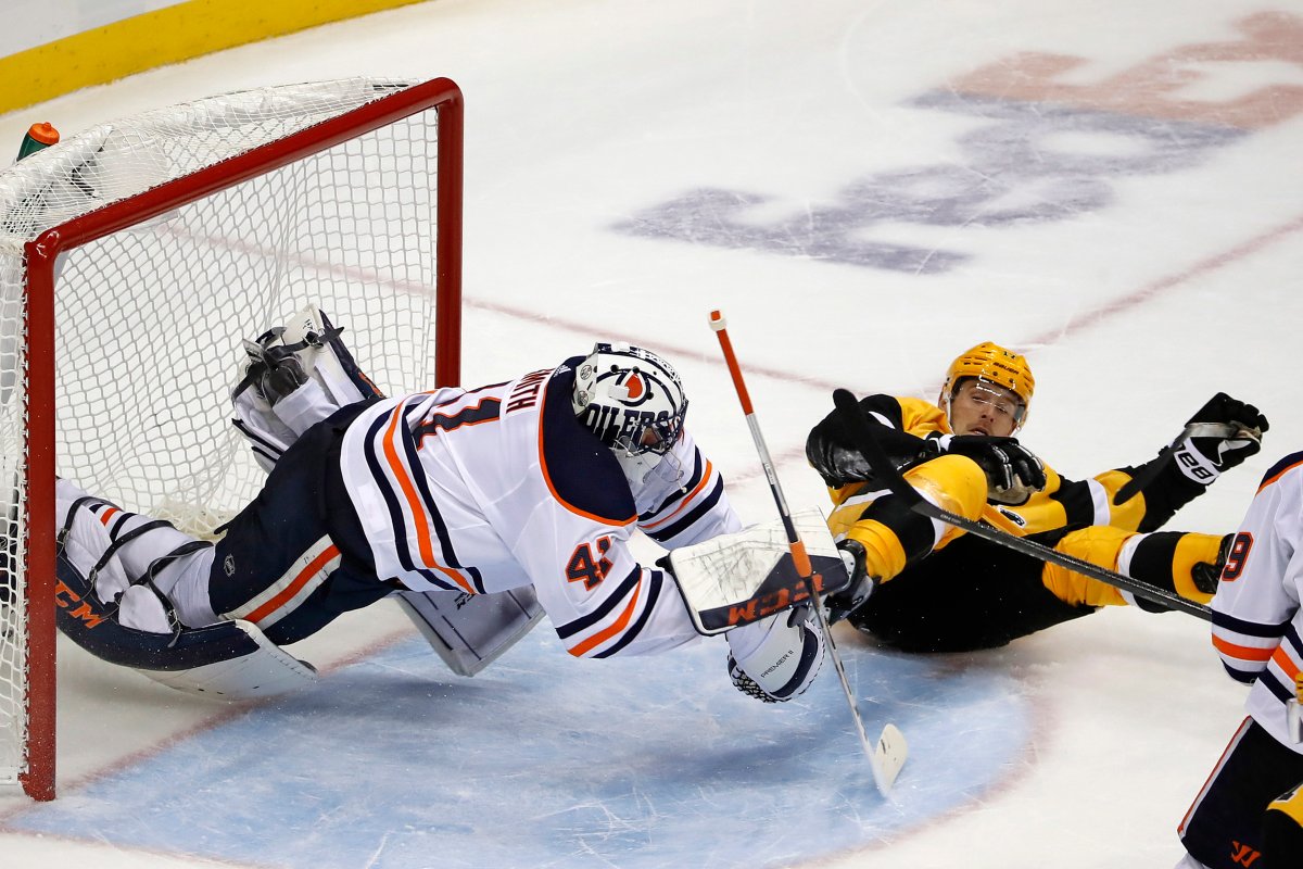 Pittsburgh Penguins' Bryan Rust, right, collides with Edmonton Oilers goaltender Mike Smith during the overtime period of an NHL hockey game in Pittsburgh, Saturday, Nov. 2, 2019. The Oilers won 2-1 in overtime. (AP Photo/Gene J. Puskar).