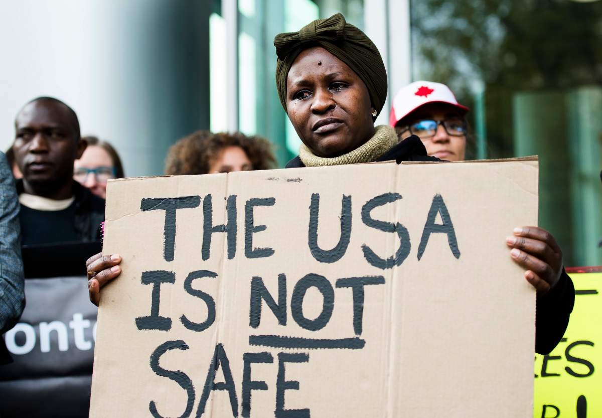 Kikome Afisa cries as she along with others protest outside the Federal Court of Canada building for a hearing of the designation of the U.S. as a safe third country for refugees in Toronto on Monday, November 4, 2019. 