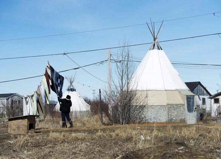 An indigenous women takes down laundry in the northern Ontario First Nations reserve in Attawapiskat, Ont., on April 19, 2016.