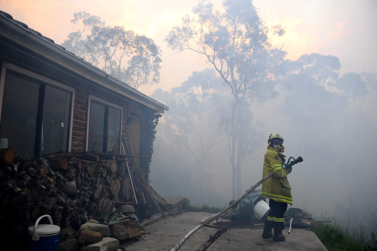 NSW Rural Fire Service and Fire and Rescue NSW personnel conduct property protection as a bushfire burns in Woodford, New South Wales (NSW), Australia, 08 Nov. 2019. (EPA/DAN HIMBRECHTS AUSTRALIA AND NEW ZEALAND OUT)