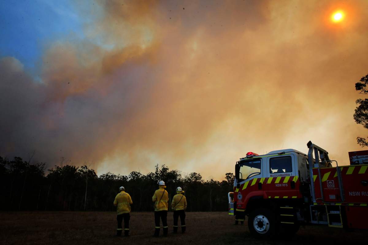 Firefighters look at a bushfire approaching in Old Bar, New South Wales, Australia, 10 Nov. 2019. (EPA/DARREN PATEMAN AUSTRALIA AND NEW ZEALAND OUT)